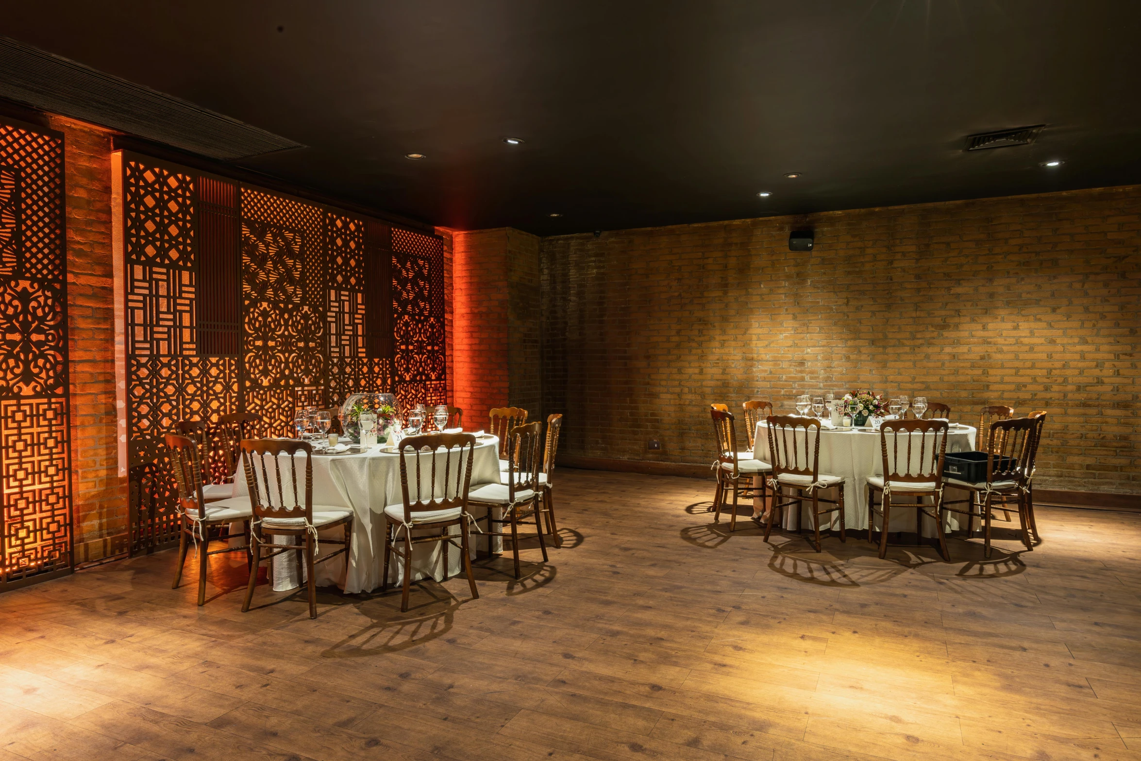 dinner tables with place settings on a wooden floor