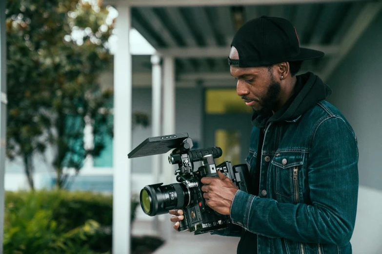 a man in black jacket holding a camera and taking picture