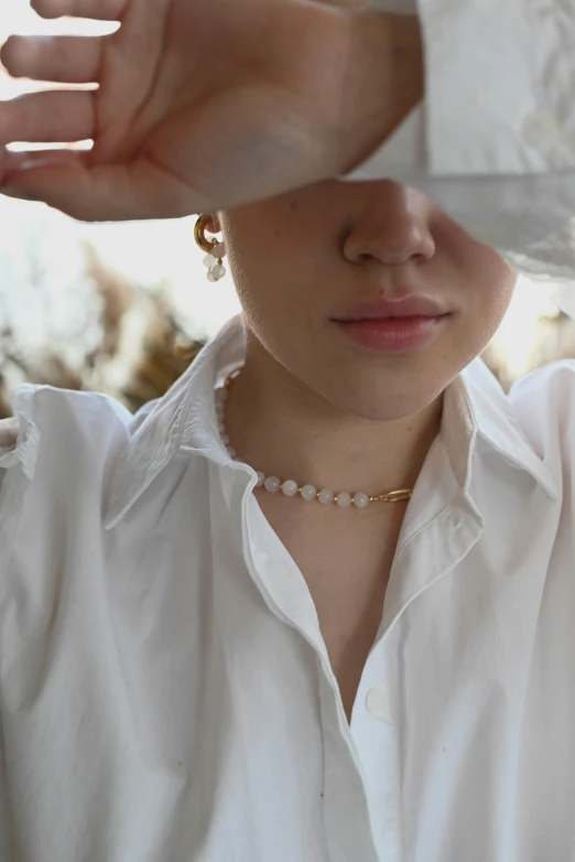 woman in a white shirt touching the top of her head