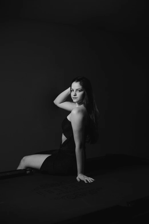 woman is sitting on the floor, in black and white