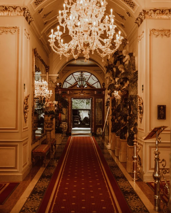 a fancy entryway to a el with ornate chandeliers hanging from it's ceiling