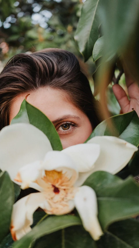 a person standing next to some flowers looking out