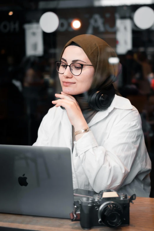 a woman with headphones sitting at a laptop