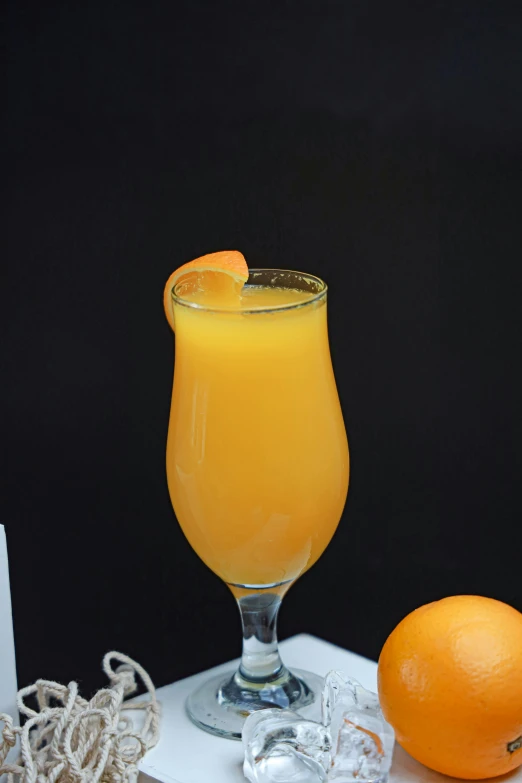 an orange juice is in a glass on the table
