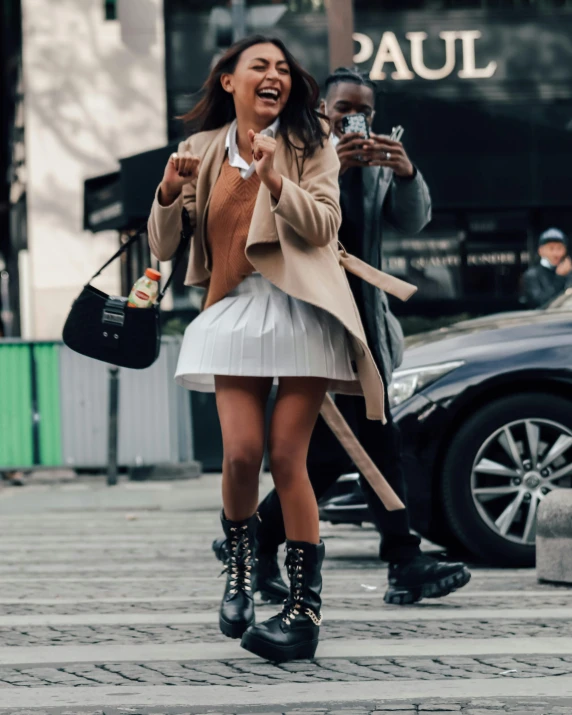 a young woman wearing high heeled boots and holding a cell phone