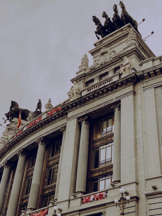 a tall building with statues and a dome