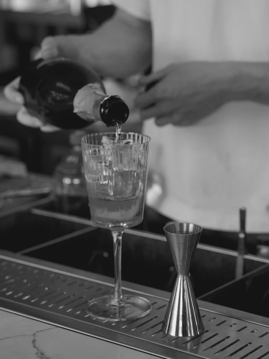 bartender pouring a drink into the glass at a bar