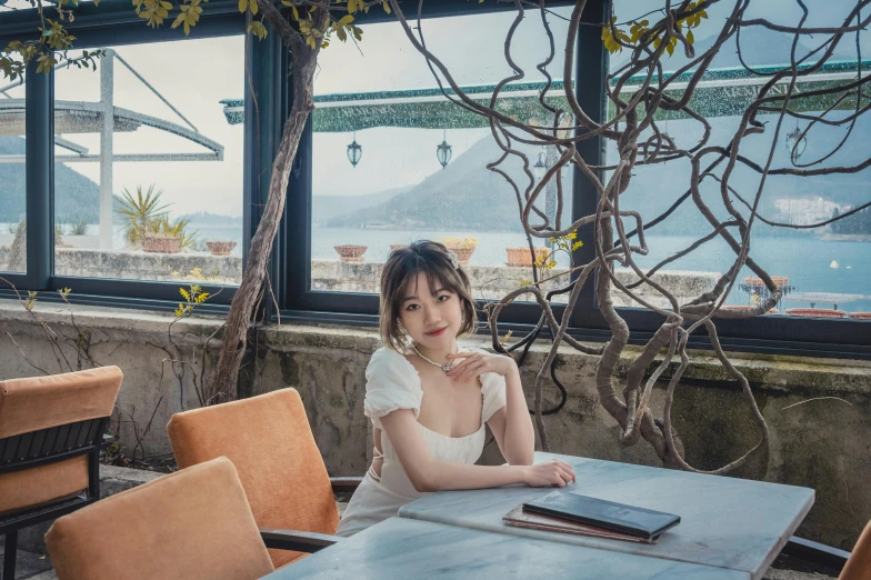 a lady in a white dress sitting at a table