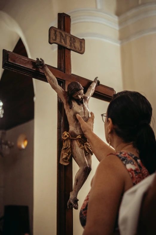 a woman placing a wooden cross on top of the cross