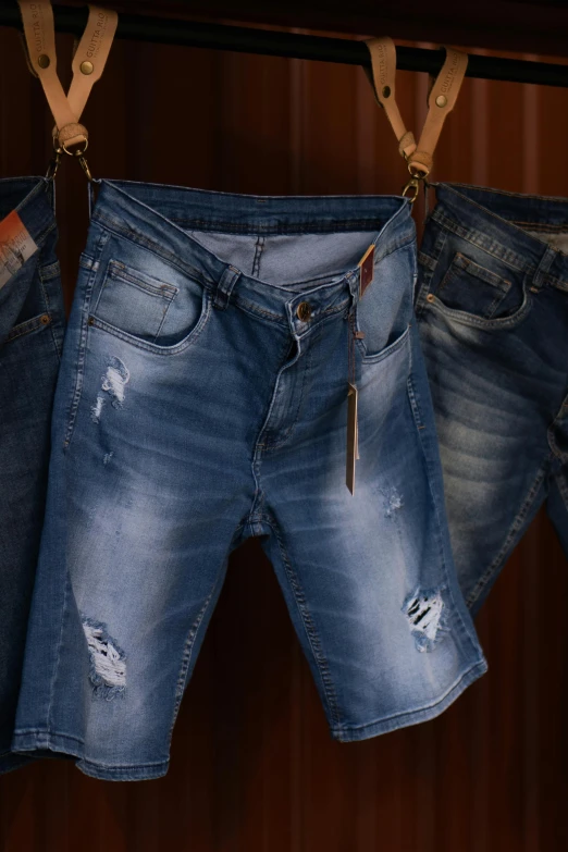 pair of small worn jeans hanging on bar