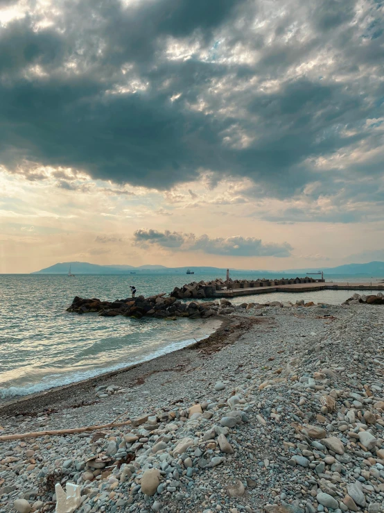 two people riding horses on an rocky beach