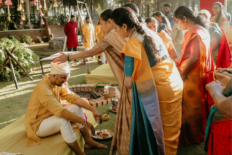 several people are gathering together in colorful outfits