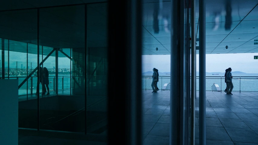 the reflection of people on glass windows in an office building