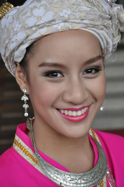 a young asian woman wearing jewelry smiling for the camera