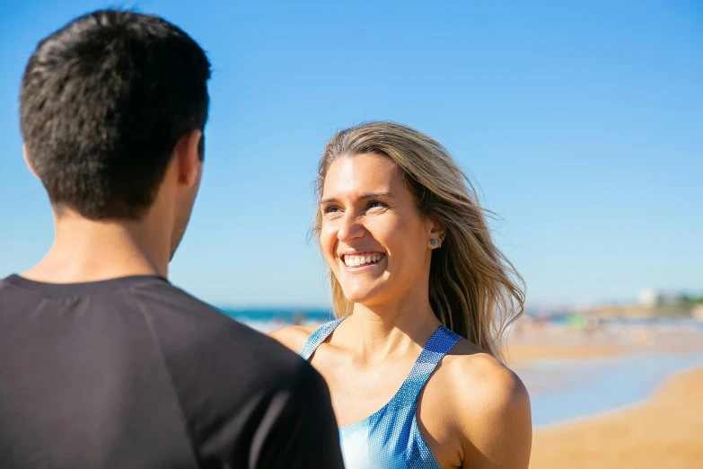 a man and woman are standing on a beach