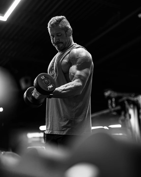 a man is working out with dumbs in the gym