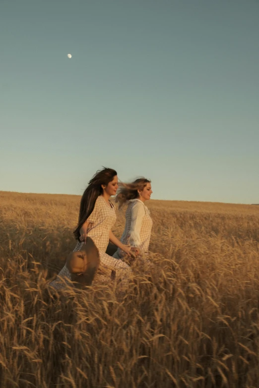 a group of girls running through the tall grass