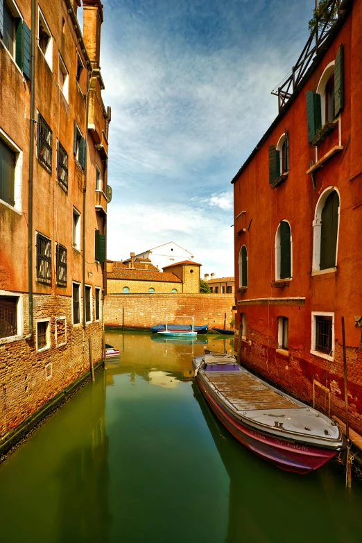 an old boat in a narrow canal next to the houses