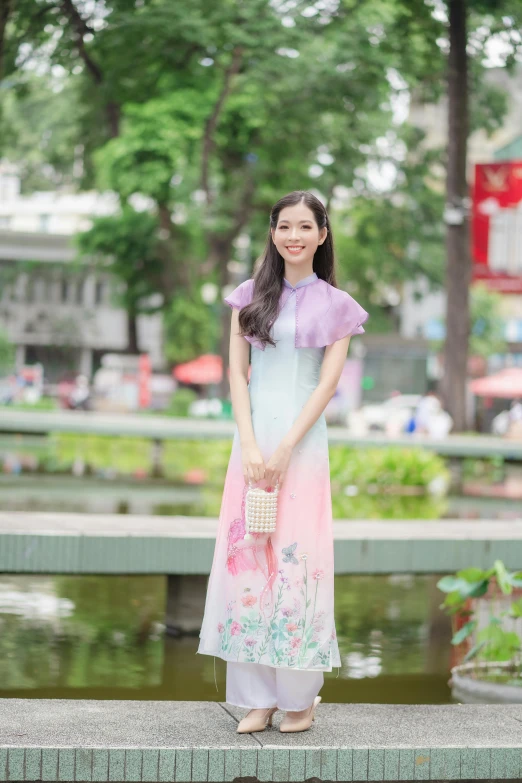 the beautiful asian lady is standing by a pond