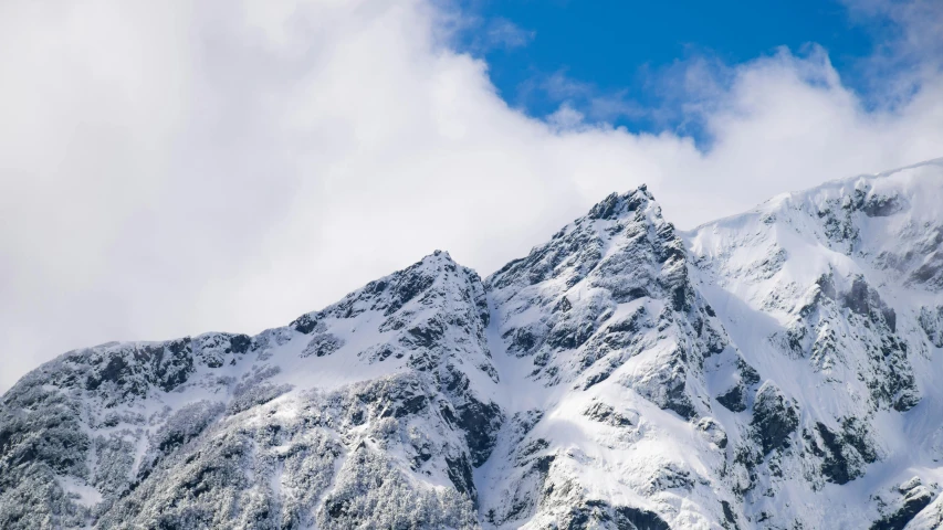 some mountain ranges covered in snow and clouds