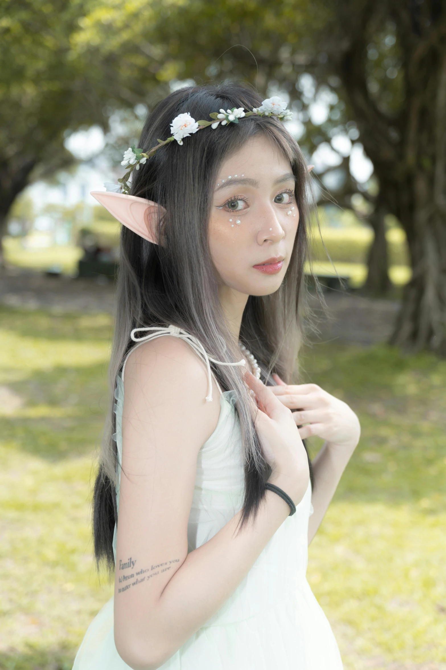 a girl wearing a flower crown in front of a park