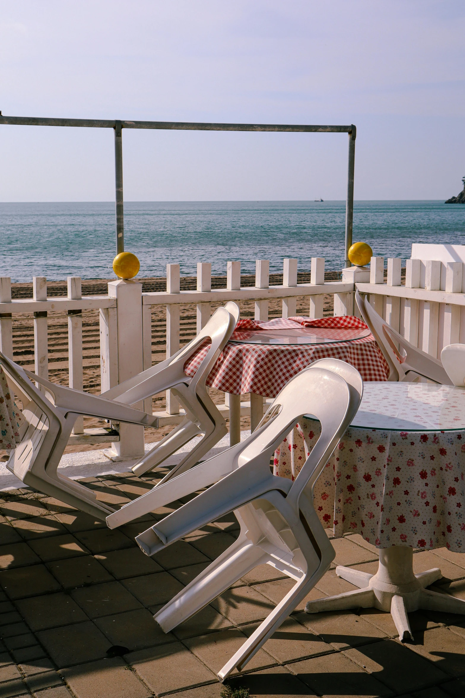 a white table and some chairs next to the ocean