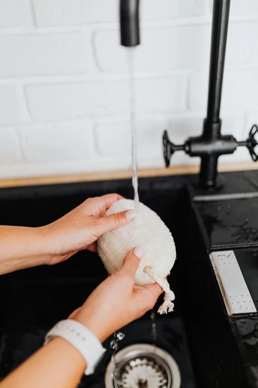 woman washing her hands while in the kitchen