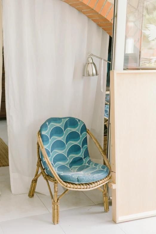 a chair sits in front of a window with a curtain