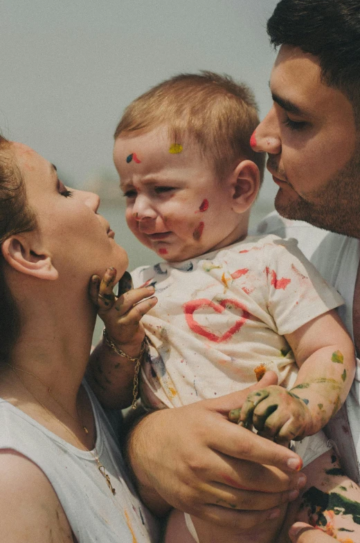 a woman and man holding a child in their lap