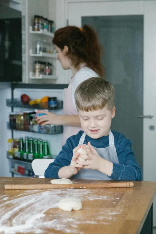 a little boy making cookies in the kitchen