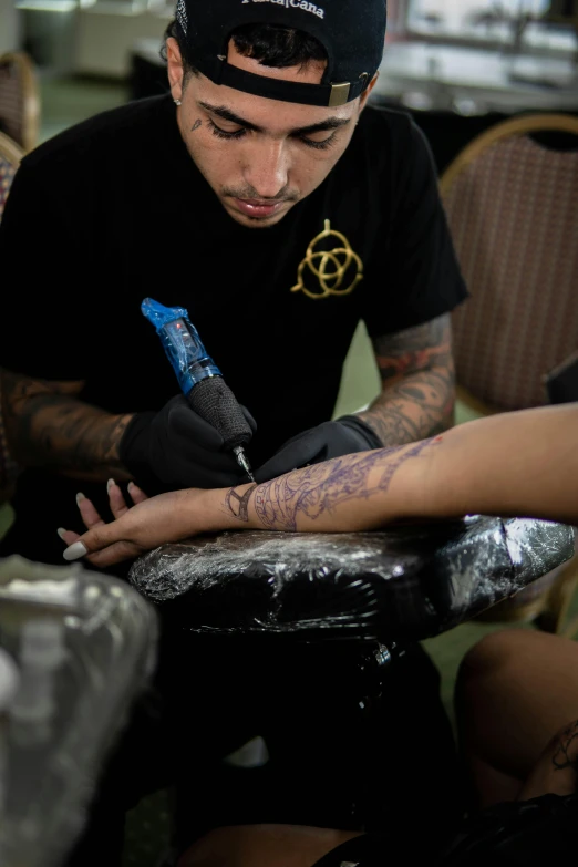 a man with a blue tattoo writing on his arm