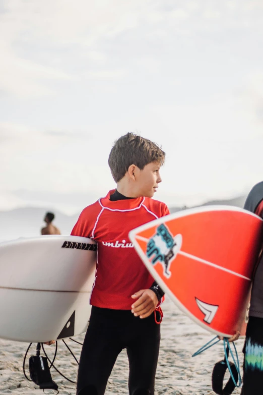 two surfers with their boards in hand on the beach