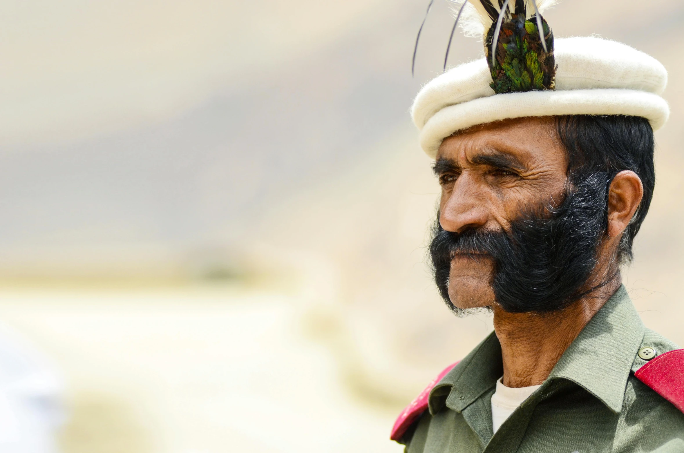 an indian soldier wearing a erfly hat and beard