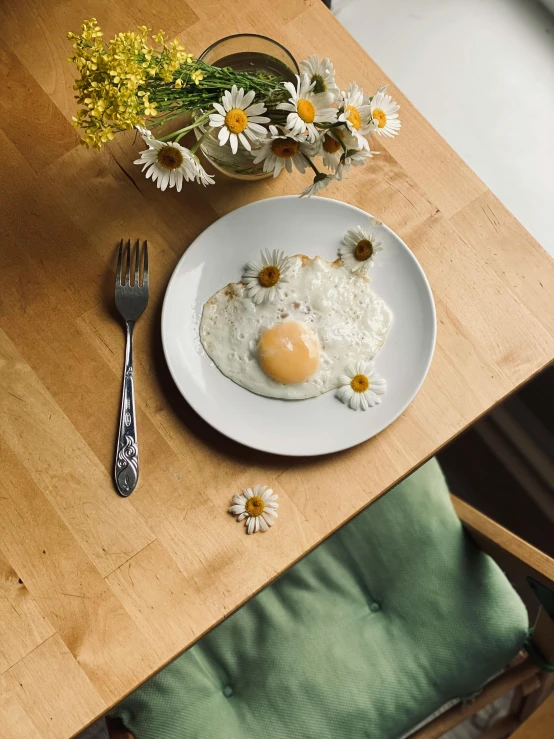 a breakfast plate with a fried egg and daisies