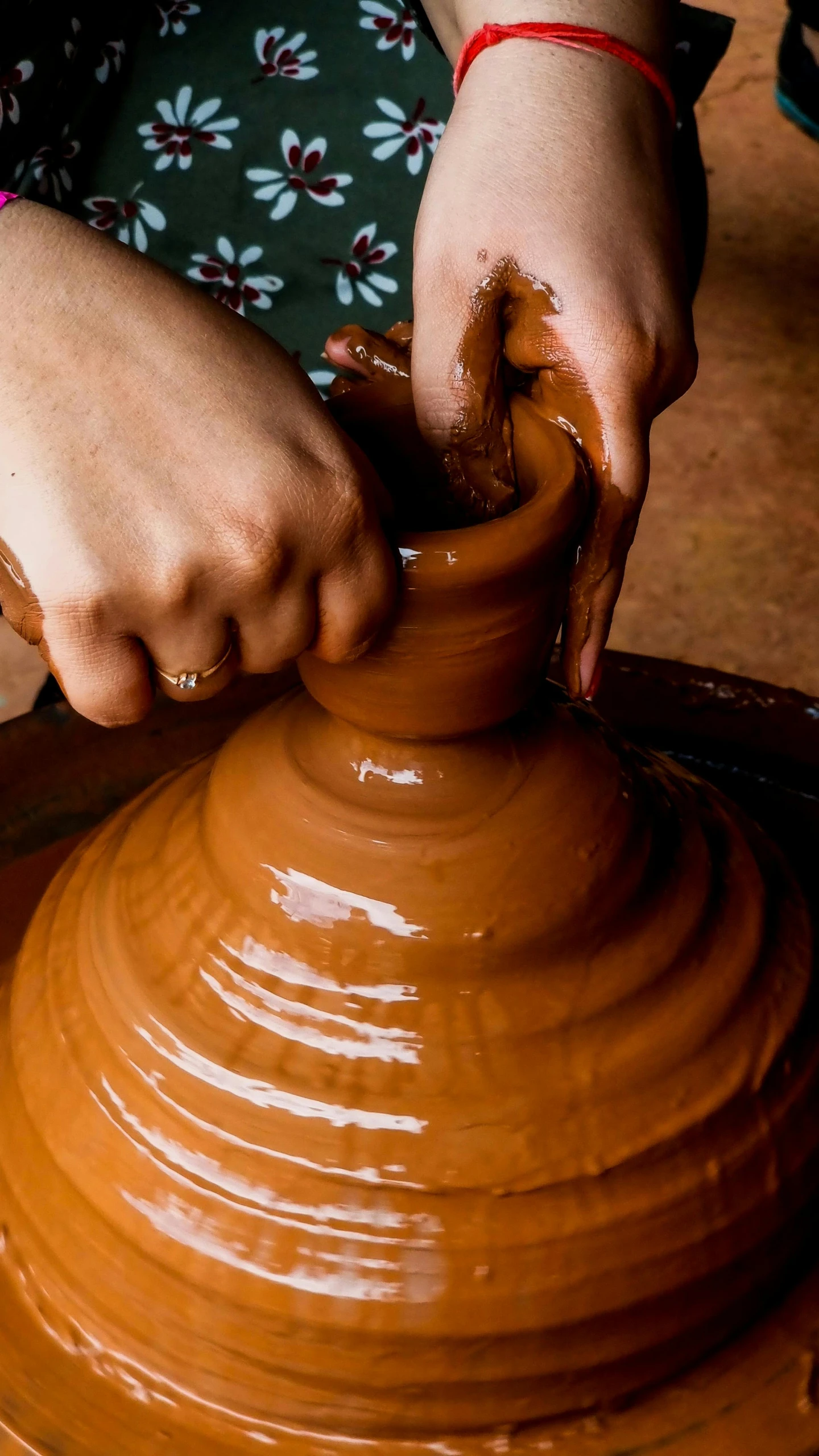 a woman is making clay on the potters wheel