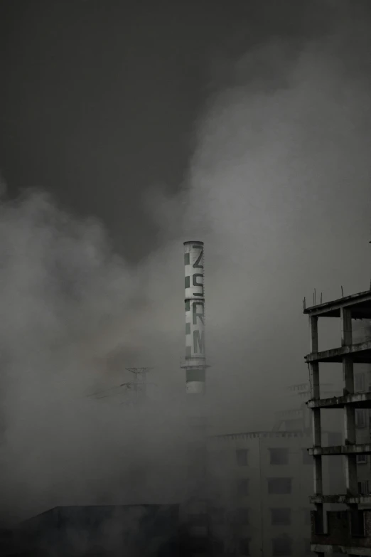 a very dark black and white po of a large tower that looks to have just fallen down