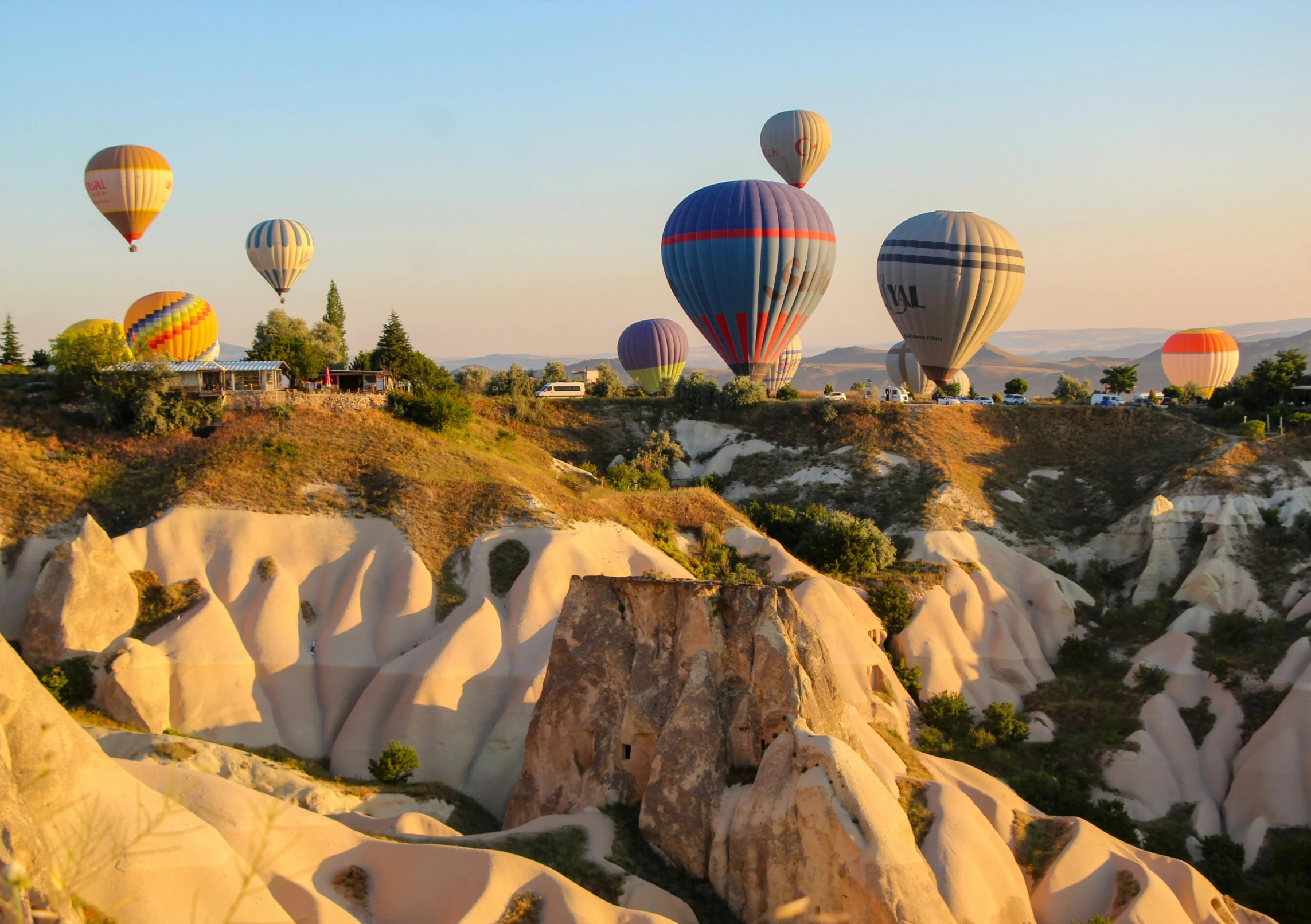  air balloons fill the sky above rock formations
