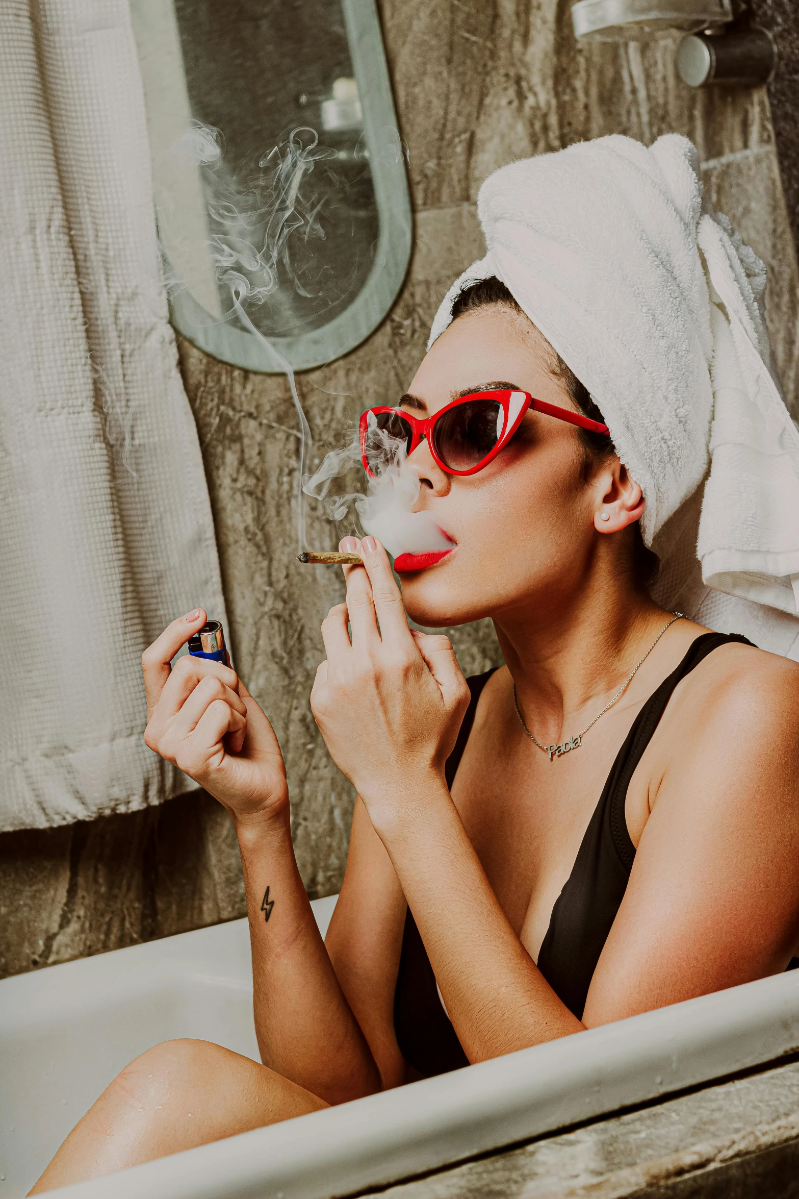 a woman wearing sunglasses while sitting in a bath tub smoking