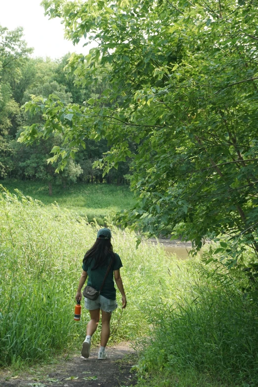 a young woman walking down a path past a field