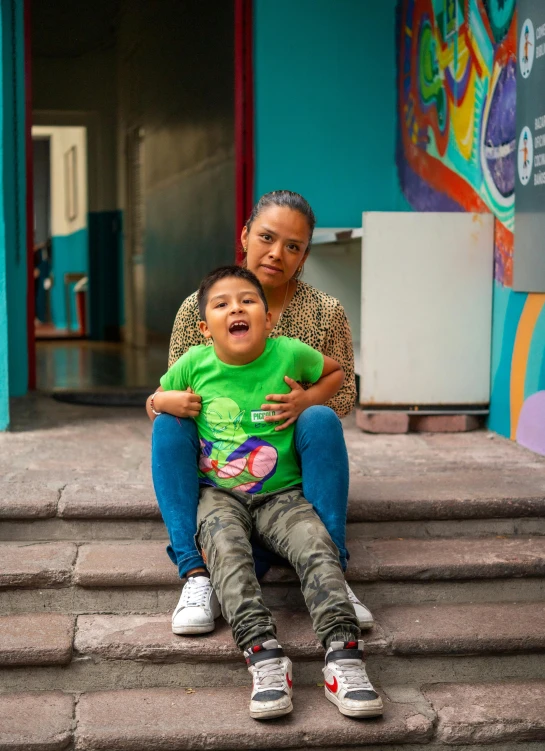 two s sitting on steps with a woman holding a toddler