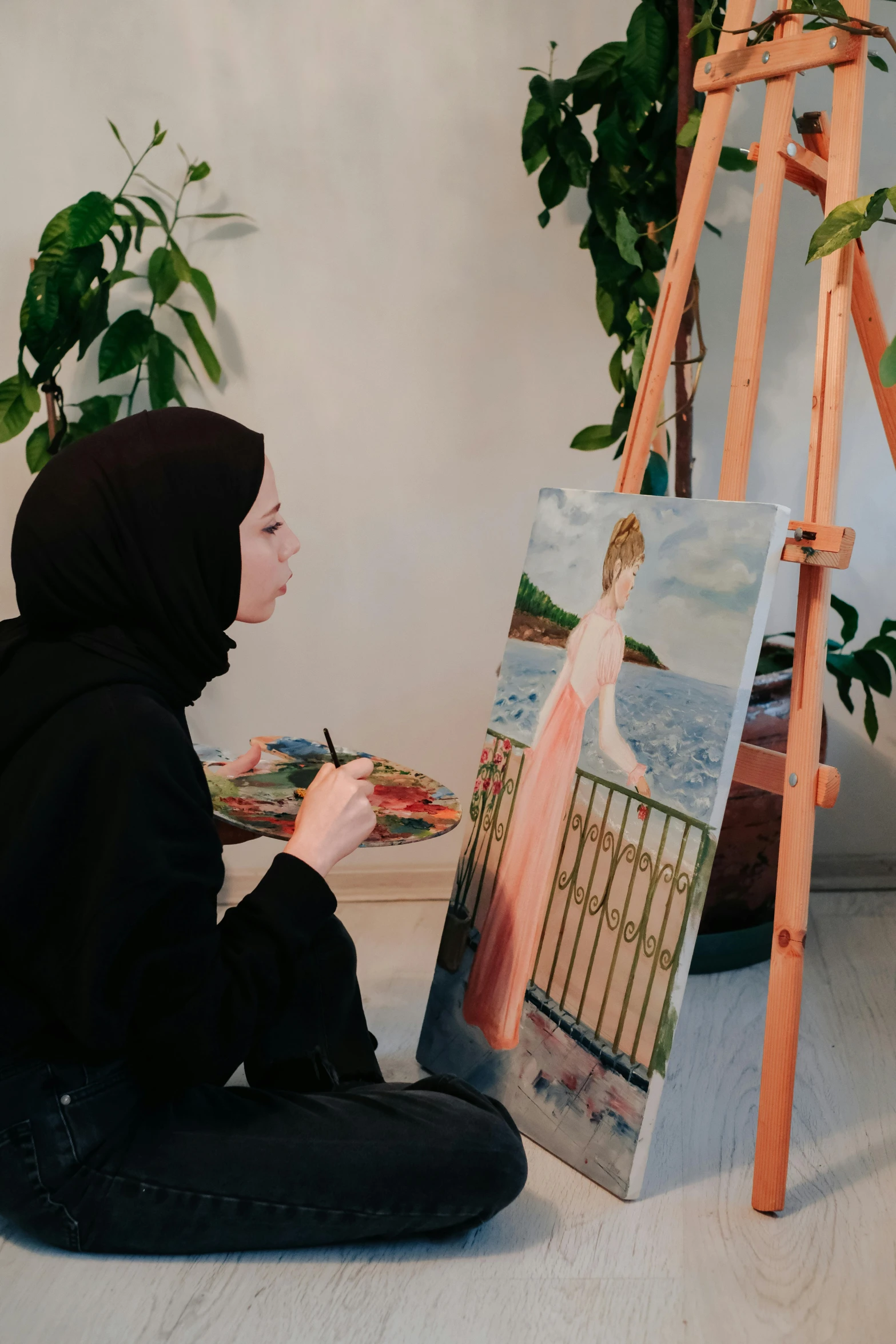 a woman is drawing in front of an easel