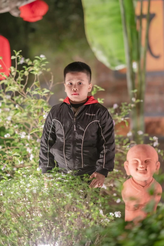 a small boy standing in front of two fake sculptures