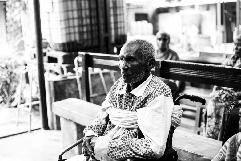 black and white pograph of a man sitting on a bench