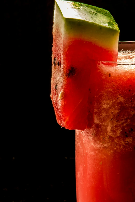 a red drink with slices of a lime and watermelon on top