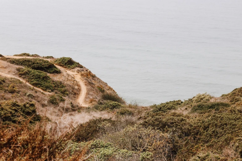 the lighthouse is built on a small hill near the beach