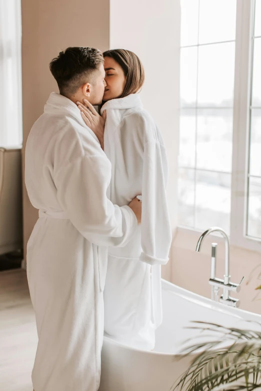 two people wearing robes are in the bathroom