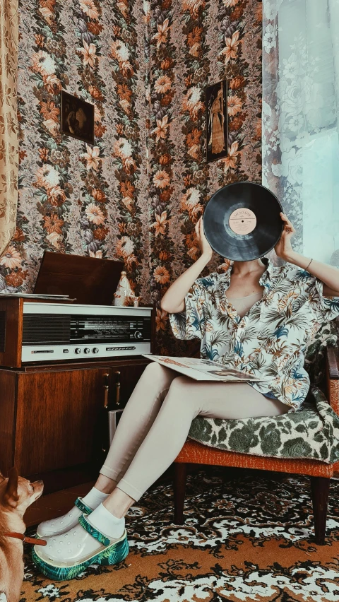 a woman sitting in a chair with a record in her hand