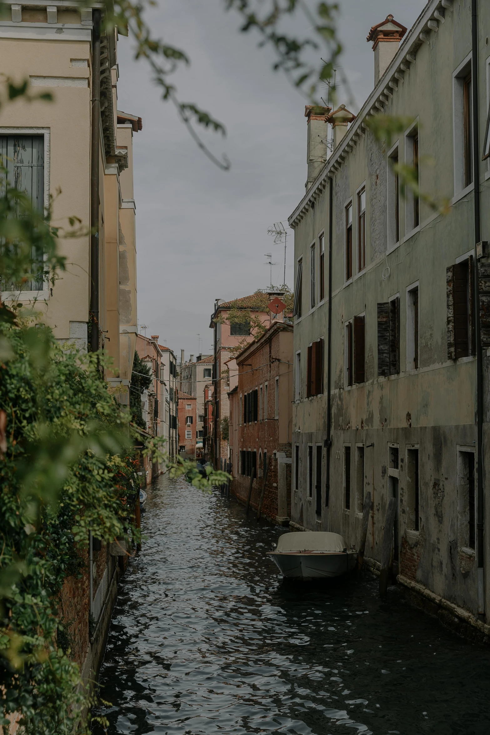 a boat floating in an alley between two buildings