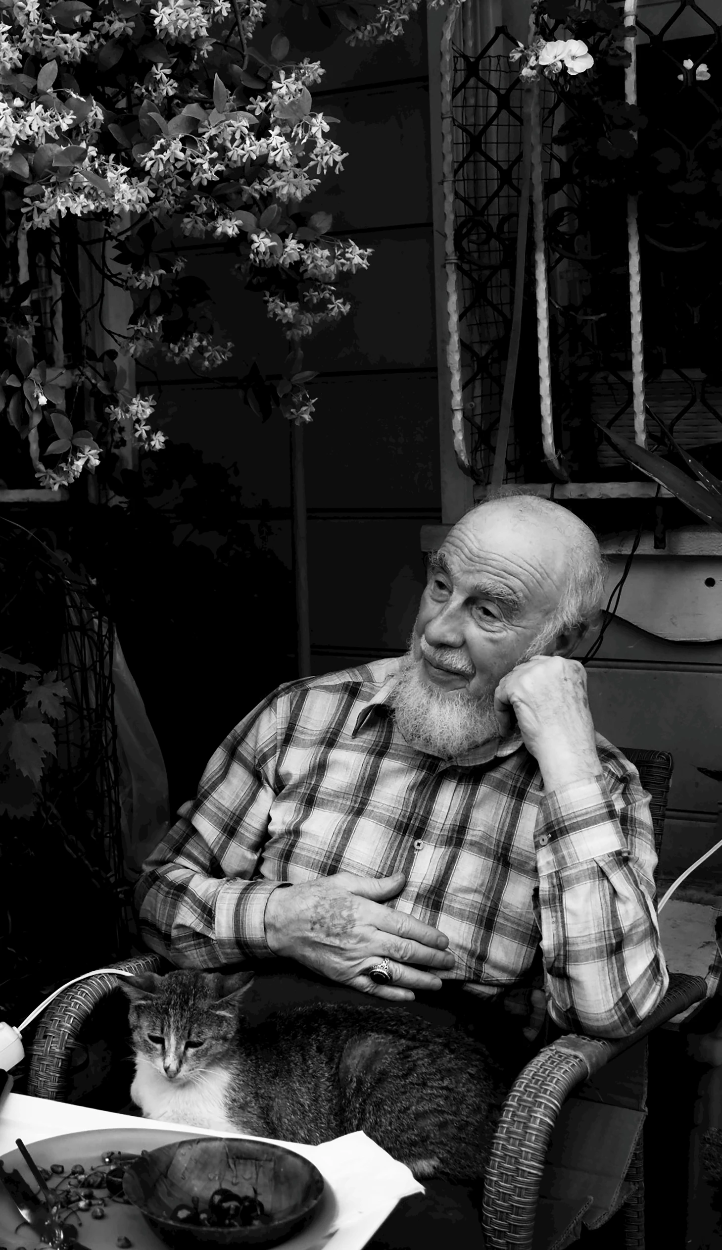 man with beard sitting at table in chair smiling and holding food