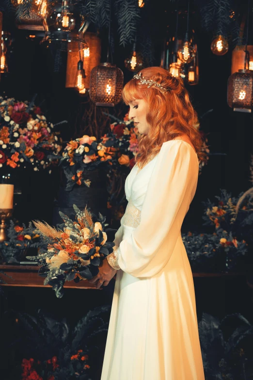 a woman is standing next to an arrangement of flowers